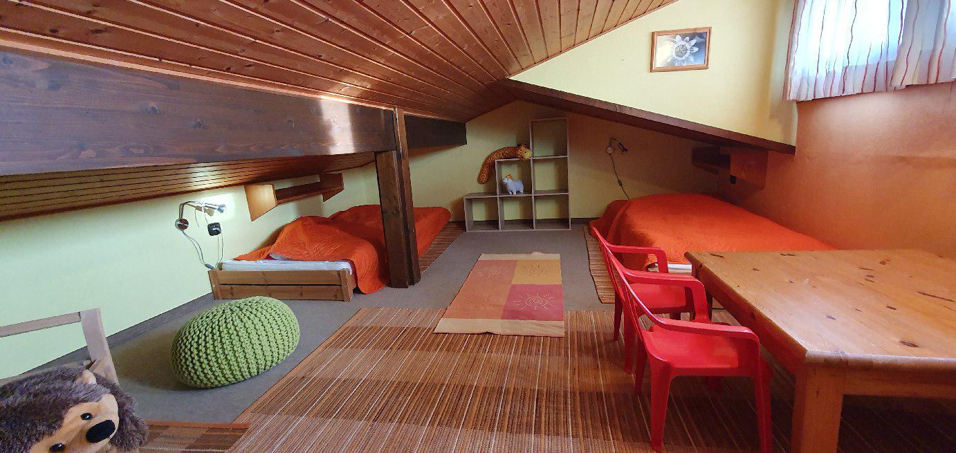 Die Koje untger dem Dach mitzwei Betten und einem Tisch mit zwei Kinderstühlen