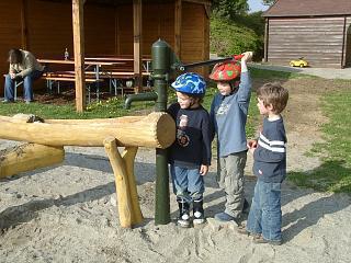 Drei Kinder bedienen die Wasserpumpe am "Matschplatz"